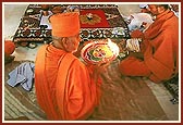 Due to fatigue, Swamishri performs arti while sitting down
