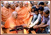 Giving sanctified flowers to devotees