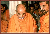 Swamishri gives a consecrated vegetable to a child