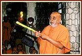 Swamishri performs the customary arti in a dried coconut cup
