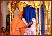 Swamishri performs the pratishtha rituals of Shri Akshar Purushottam Maharaj in the central shrine