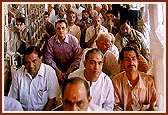 Devotees engaged in the partishtha rituals beneath the mandir dome 