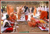 Swamishri sprinkles water, kumkum, etc as part of the shilanyas rituals