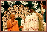 Swamishri blesses Laljibhai with the holy garland