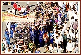 An all-in-one murti in a decorative float with women devotees carrying the auspicious kalashas during the rally