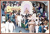 Women devotees respectfully pull a float