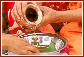 Swamishri bathes Shri Harikrishna Maharaj during the rituals 