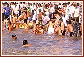 Devotees bathe and pray in the river Ghela