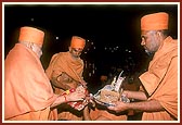 Swamishri sanctifies a coconut and 'chundadi' to Thakorji that was then offered as an honor to the river Ghela