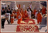 Swamishri is taken up the steps leading from the gateway to the shrines in the main mandir 