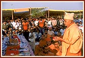 Swamishri showers flowers on the 450,000 mantra books placed in the Vedika