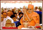 Swamishri holds the auspicious Kalash aloft