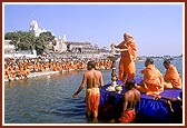 Swamishri bathes Shri Harikrishna Maharaj with the holy waters of river Ghela