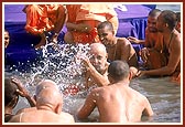 Swamishri sprinkles the holy river water on the senior sadhus