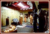 Swamishri and devotees engaged in arti and prayers