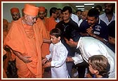 Swamishri affectionately blesses two satsangi balaks who then embrace Swamishri with love