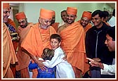 Swamishri affectionately blesses two satsangi balaks who then embrace Swamishri with love