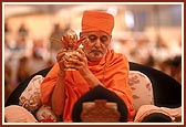 Swamishri holds the kalash during the yagna