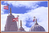 A view of the mandir pinnacle and domes complete with kalashas and flags