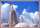 A view of the mandir pinnacle and domes complete with kalashas and flags