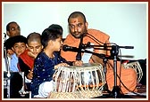 A balak plays the tabla during Swamishri's puja on Bal Din 
