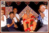 The leading devotees of New Zealand honor Swamishri with a garland