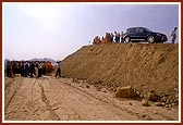 Swamishri views the ongoing construction of monument from the mud-ramp