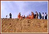 Swamishri views the ongoing construction of monument from the mud-ramp