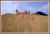 Swamishri views the ongoing construction of monument from the mud-ramp
