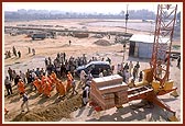 Swamishri is carried in a chair towards the monument