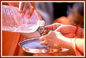 Swamishri also bathes Shri Ganapatiji found at the Akshardham site with panchamrut and water