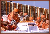 Swamishri pours cement around the first stone laid for the shikharbaddh mandir in New Delhi