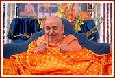 Swamishri is honored with a decorative orange cotton sheet