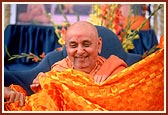 Swamishri is honored with a decorative orange cotton sheet