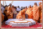 As part of the ritual, Swamishri splits the coconut and raises his hand in joy