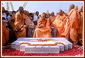 As part of the ritual, Swamishri splits the coconut and raises his hand in joy