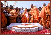 As part of the ritual, Swamishri splits the coconut and raises his hand in joy