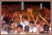 Devotees jubilantly get drenched by the shower of holy, colored water 