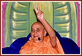 'One who has the association of God and his holy Sadhu is redeemed ...' Swamishri raises his hand during his blessings in an assembly