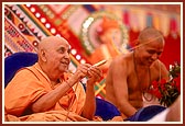 Swamishri sprays the sanctified colored water on the distinguished guests