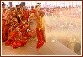 ... and while he dances he is drenched by a shower of colored water directed by Swamishri