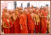 Pujya Mahant Swami, Pujya Tyagvallabh Swami and sadhus being blessed by Swamishri with the shower of colored water