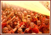 Swamishri sprays the colored water on the eagerly awaiting sadhus
