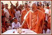 A young boy gives a ball of flowers to Swamishri to place it on the shrine. Swamishri then tells the boy to accompany him during the pradakshina of the Smruti mandir