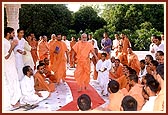 A young boy gives a ball of flowers to Swamishri to place it on the shrine. Swamishri then tells the boy to accompany him during the pradakshina of the Smruti mandir