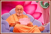 Swamishri engrossed in reading a letter during the morning session of Shri Hari Jayanti Celebration