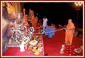 Swamishri devotionally rocks Shri Harikrishna Maharaj after performing the festival arti