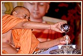 Out of reverance and devotion, Swamishri ritually bathes Shri Harikrishna Maharaj with panchamrut and water