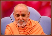 On stage, Swamishri attentively listens to the devotees