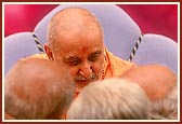 On stage, Swamishri attentively listens to the devotees